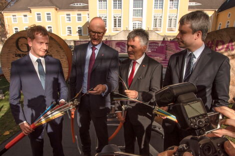 4 Männer halten zur feierlichen Eröffnung eine Glasfaserkabel in der Hand. Auf der linken Seite Sachsens Ministerpräsident Kretschmar.
